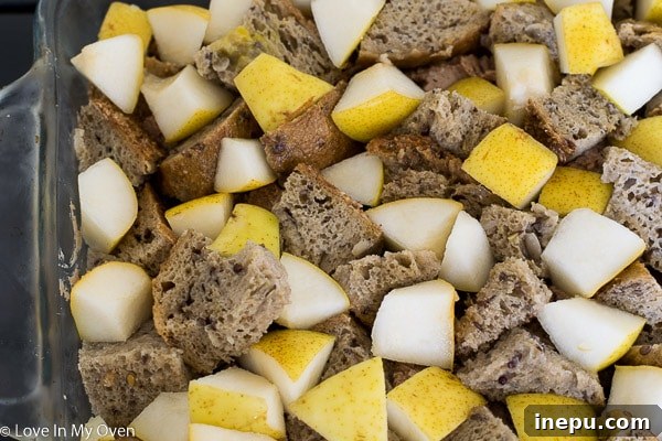 Cubed pears and bread in a baking dish for French toast