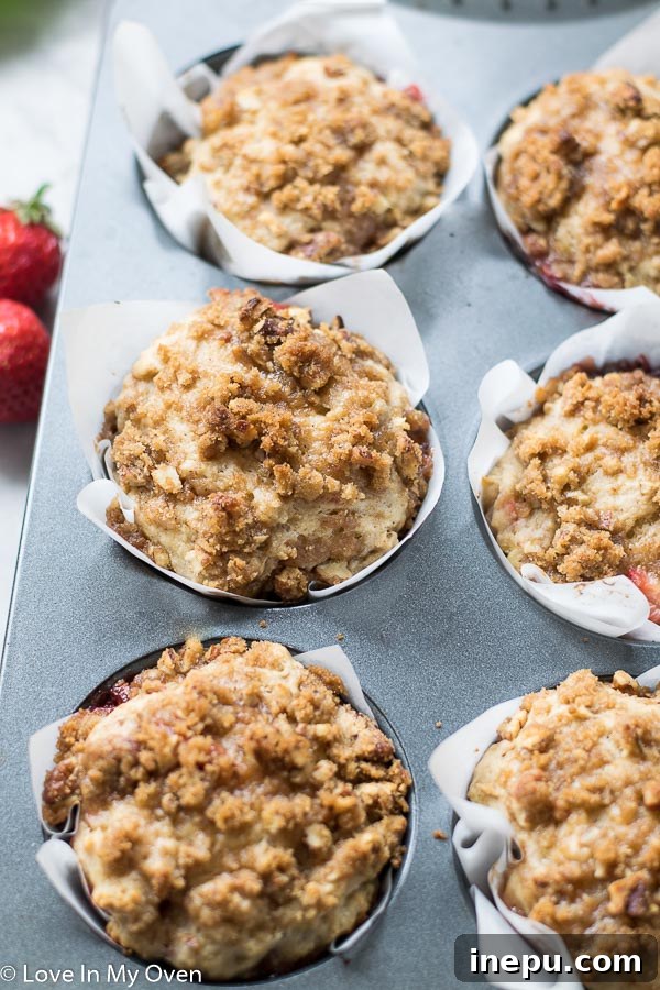 Close-up of fresh strawberries and chopped rhubarb, key ingredients for muffins.
