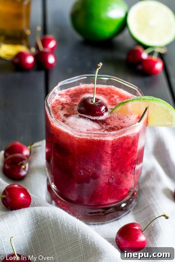 Crimson Cherry Delight 2 Refreshing Cherry Lime Whiskey Sour cocktail garnished with a cherry and lime slice