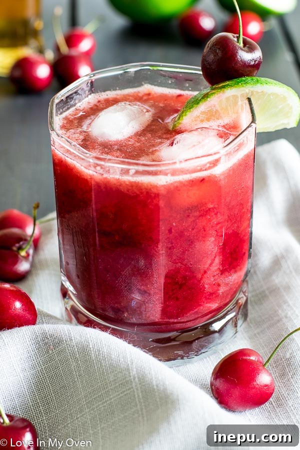 Crimson Cherry Delight 5 Garnished Cherry Whiskey Sour cocktail with fresh cherries and lime slices, ready to be served