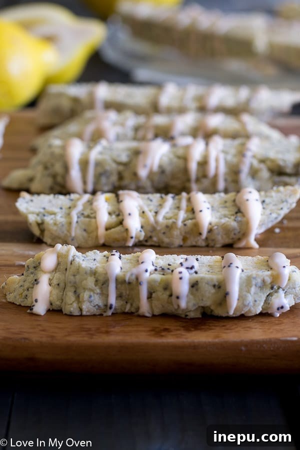 Zesty Lemon Poppy Seed Biscotti 7 Close-up of several lemon poppy seed biscotti artfully stacked next to a cup of tea