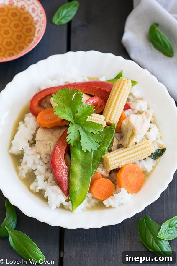 Close-up of vibrant Thai Green Chicken Curry in a bowl, showcasing chicken and vegetables.