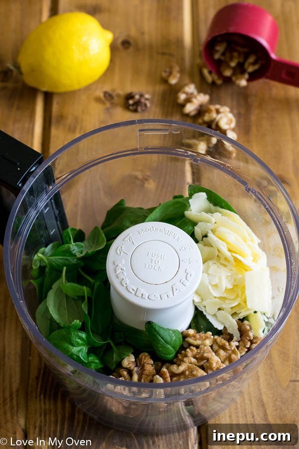 A vibrant selection of fresh ingredients including basil, walnuts, garlic cloves, and grated Parmesan cheese, neatly arranged and ready to be transformed into pesto.