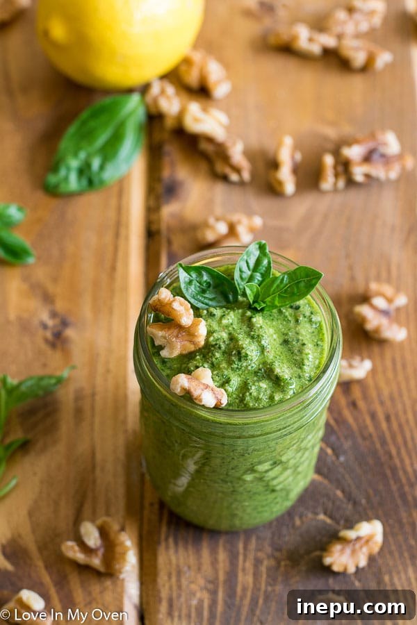 A rustic bowl filled with homemade walnut basil pesto, featuring a wooden spoon, set against a backdrop of fresh basil leaves, evoking a sense of natural freshness.