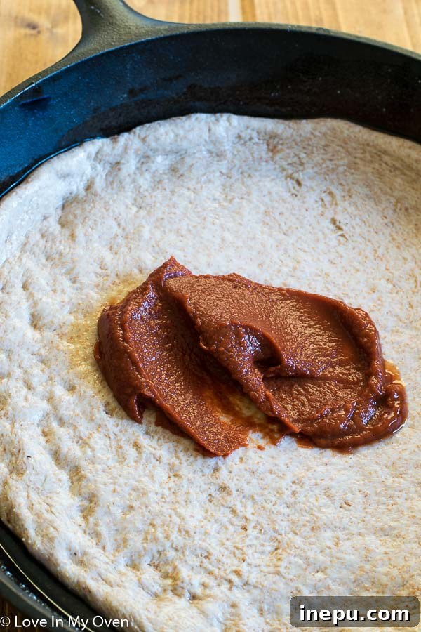 Sweet & Savory Chorizo Onion Pizza 5 A ball of whole wheat pizza dough rising in a bowl, ready for shaping.