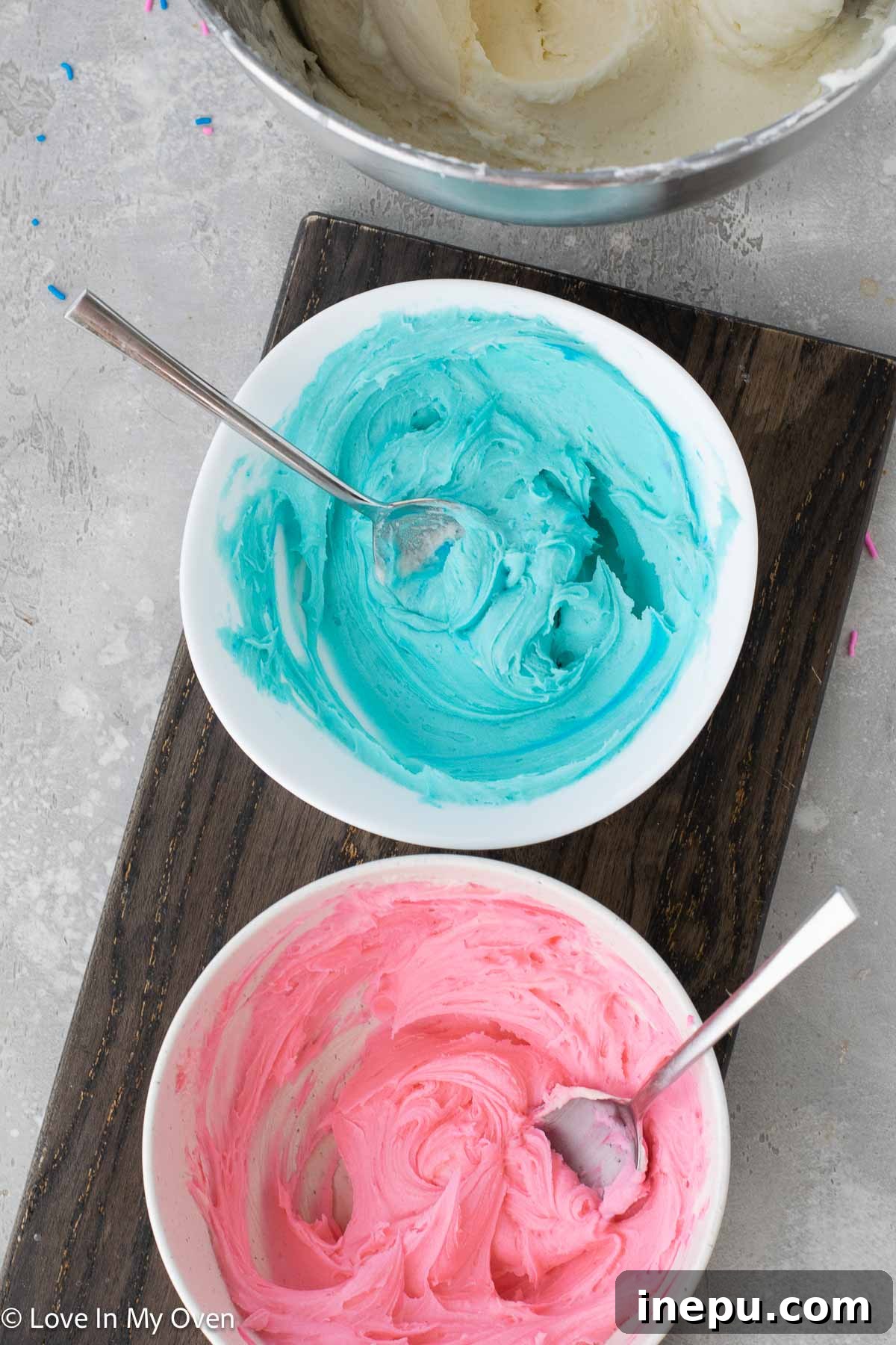 Sweet Gender Surprise 9 Colored frosting being piped into the hollowed center of a white chocolate cupcake.