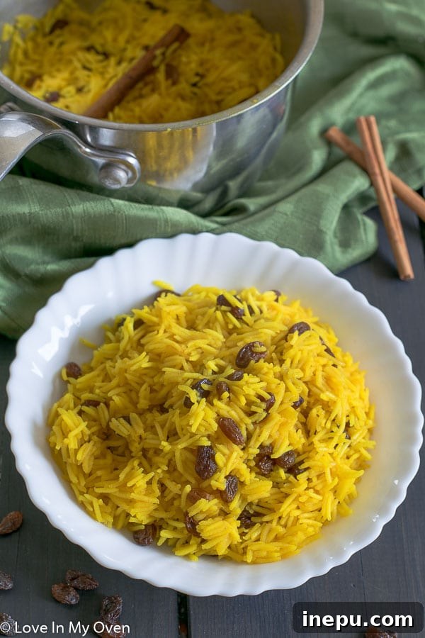Cape Malay Golden Rice 5 Overhead view of South African Yellow Rice in a ceramic bowl, garnished with a sprig of fresh herbs, emphasizing its inviting color.
