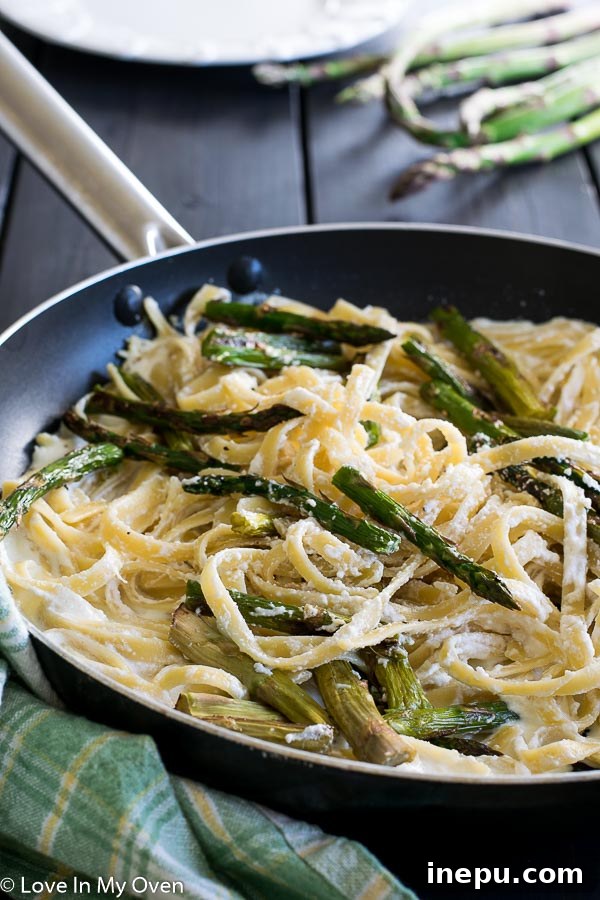 Golden Roasted Asparagus Pasta 5 Plated roasted asparagus and ricotta fettuccine with a fork