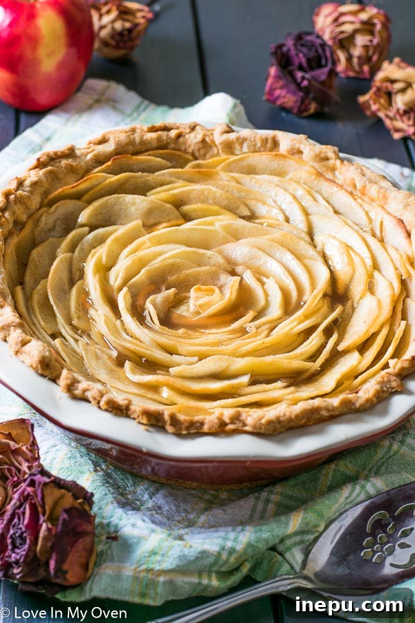 Sliced Salted Caramel Apple Rose Pie with a generous drizzle of caramel sauce