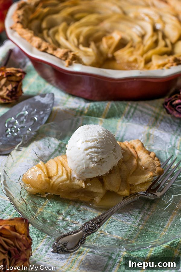 Close-up of a single slice of apple rose pie, showcasing the beautiful layers of apples and flaky crust